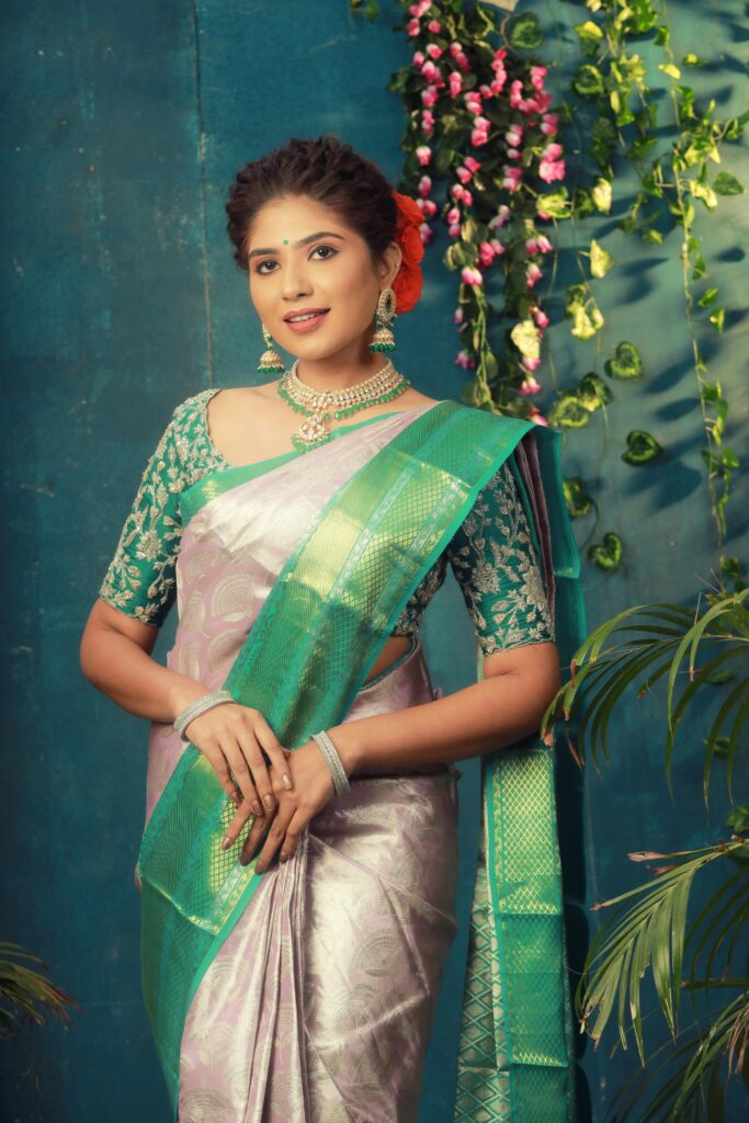 A beautiful women in a green and silver saree